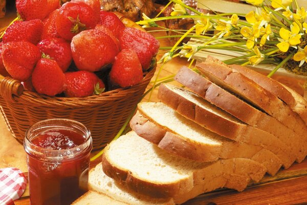 Pane con marmellata e cesto di fragole nella decorazione dei fiori