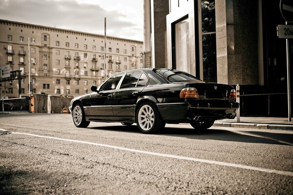 A black car is parked in the city