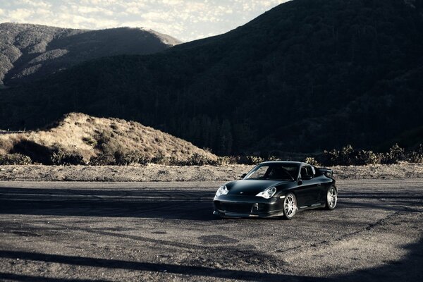 Berge, ein düsterer Himmel und ein porsche carrera 9114s