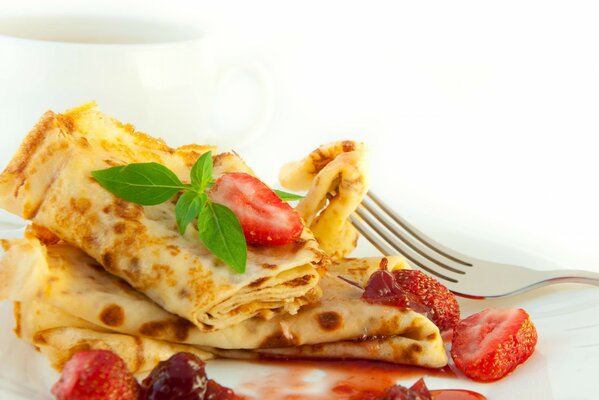 Frittelle con marmellata di fragole su sfondo bianco