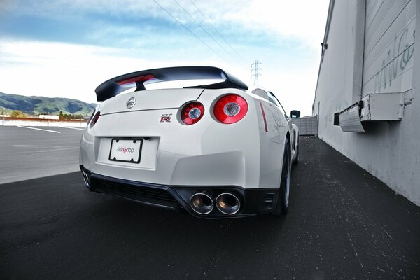 Nissan R35 blanco en la pista al pie de las montañas