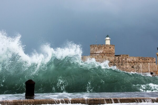 The lighthouse is covered by a high wave