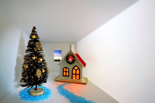 An empty room with a Christmas tree and a house