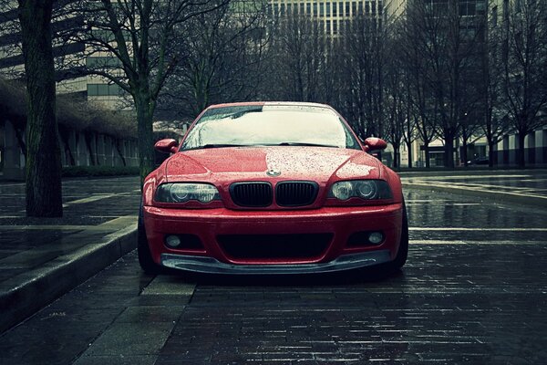 Rosso BMW e46 in città piovosa