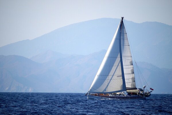 Sur le fond des montagnes-un yacht naviguant sur la mer