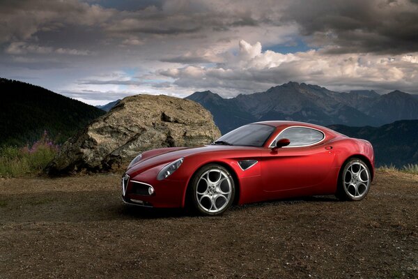 Red Alfa Romeo on the background of a mountain landscape