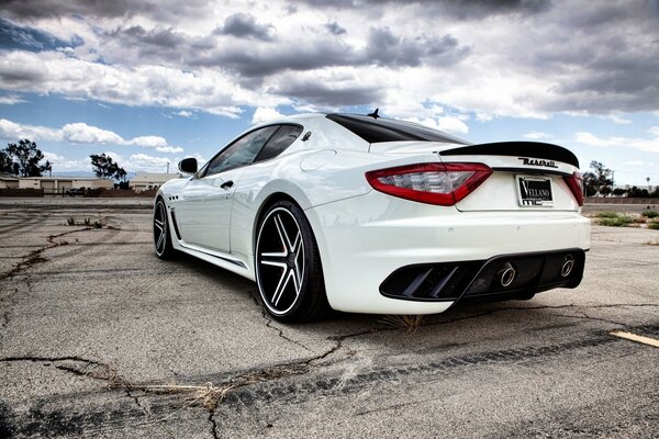 Un Maserati blanco contra un cielo nublado