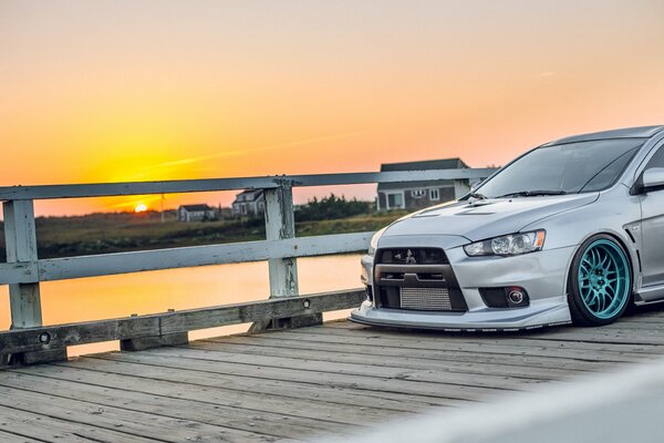 Gray Mitsubishi on the bridge with sunset view