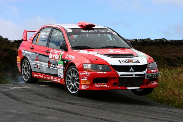 Une voiture de sport Mitsubishi de couleur rouge participe à la course