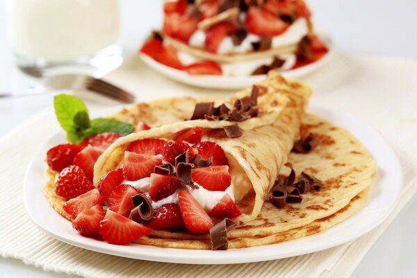 Delicious pancakes with strawberries in chocolate