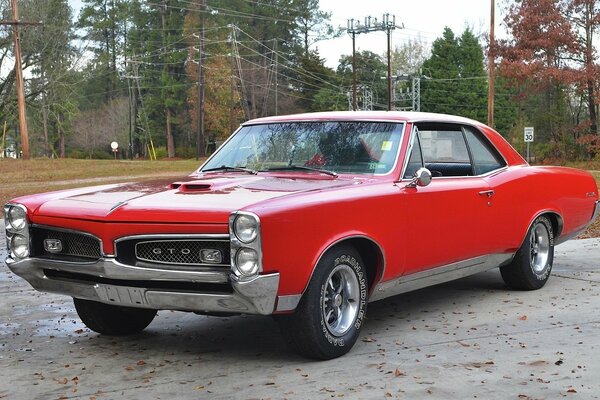 Pontiac rouge classique sur la route de campagne