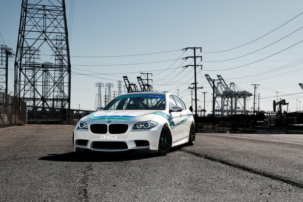 White car with blue stripe under power lines