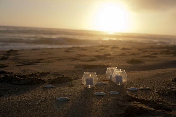 Bougies dans des verres au bord de la mer