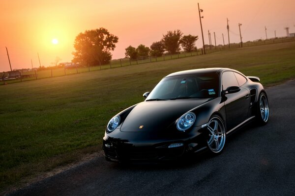 Porsche 911 Turbo negro en una puesta de sol