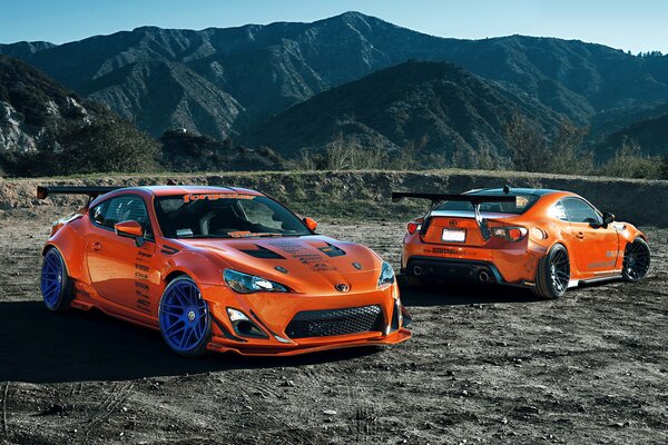 Two orange tuned Toyotas