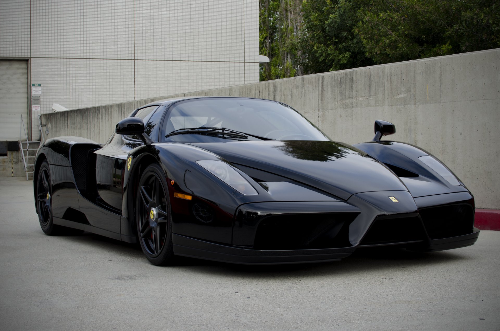 ferrari enzo noir ferrari vue de face bâtiment clôture