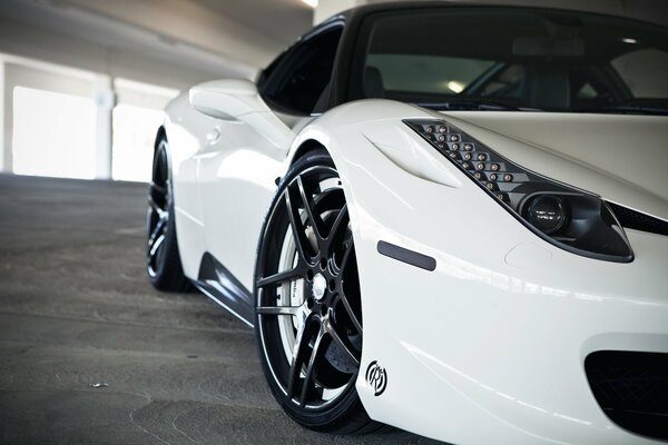 A white car with beautiful disks parked