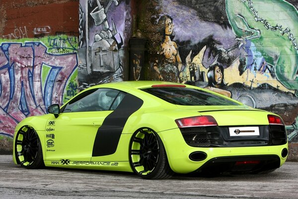 Light green audi r8 on the background of a wall with graffiti