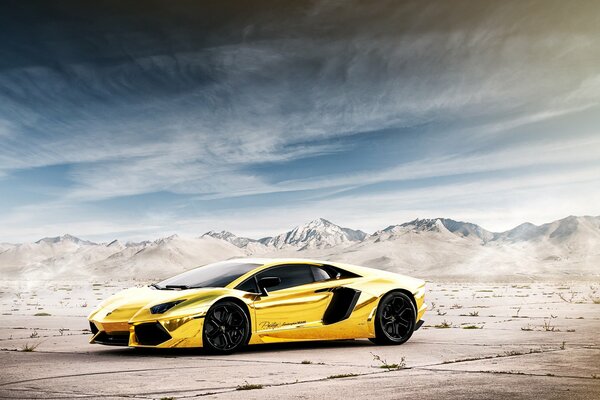 Goldenes Chrom Lamborghini auf dem Hintergrund der Berge