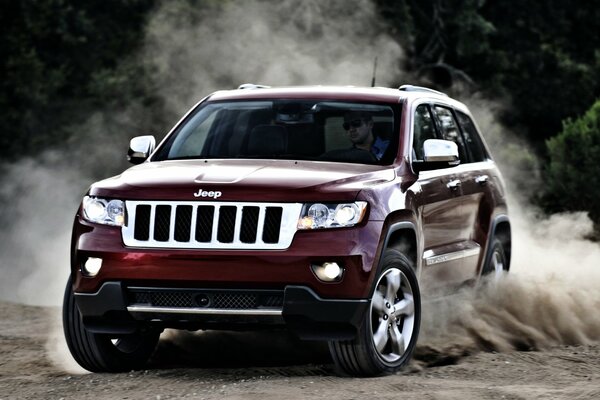 Red Jeep Cherokee drifts/turns in the sand