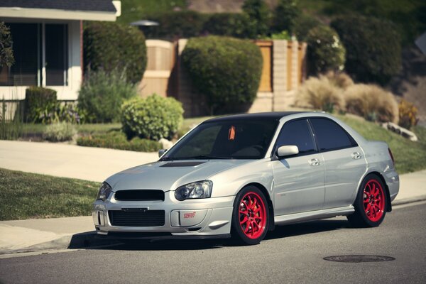 Voiture argentée Subaru Impreza près de la maison