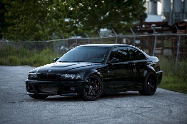 BMW noir et arrière clôture de maille