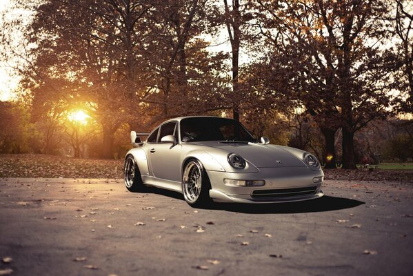 Silver Porsche, against the background of natural beauty with a bright sun