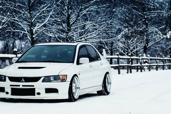 Mitsubishi lancer blanc sur la neige en hiver