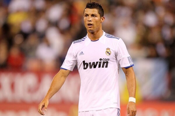 Footballeur avec un uniforme blanc marchant sur le terrain