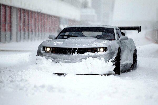 El chevrolet camaro ZL1 de invierno corta una tormenta de nieve