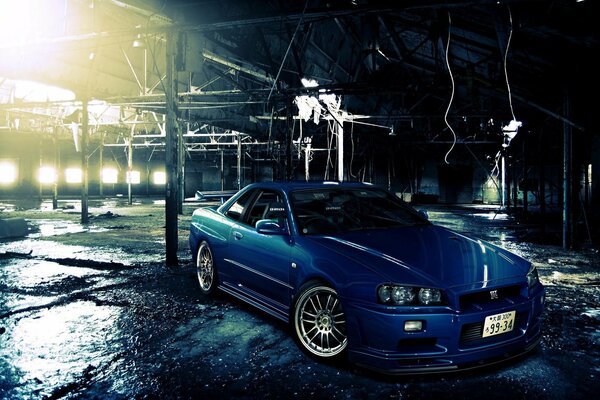 Nissan Skyline bleu illuminé par des projecteurs