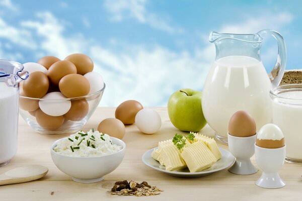 Dairy products and eggs on the table against the sky