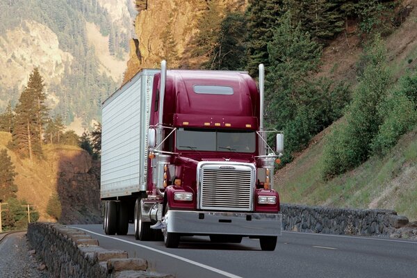 A truck with a red cab rides at the slope