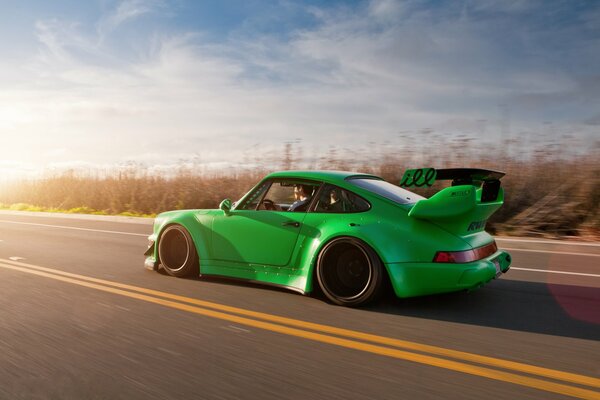 Automobile verde messa a punto di Porsche 911 sulla strada