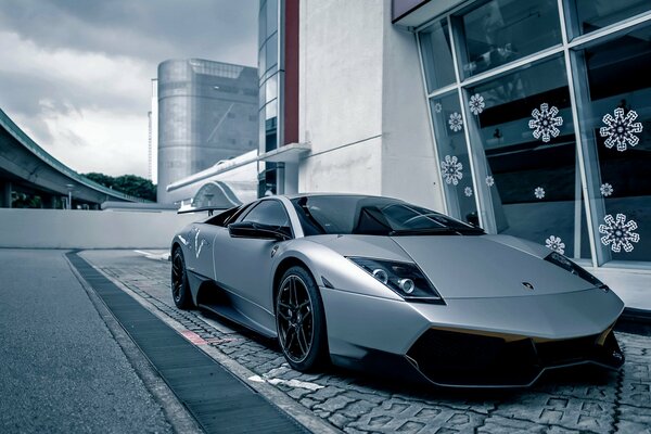 A grey Lamborghini car on the sidewalk