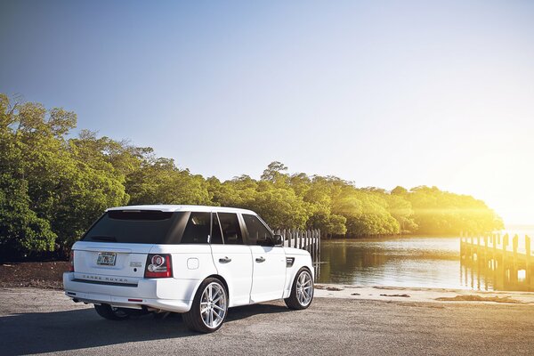 Range rover blanco en la orilla al amanecer