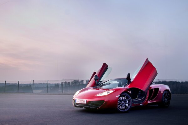 Red sports car with doors opening up