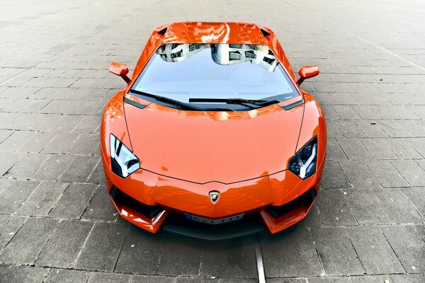 Orange Lamborghini Aventador sur pavés