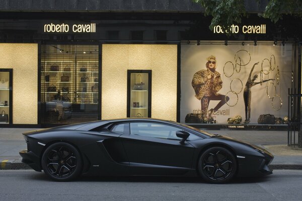Expensive black Lamborghini stopped at Italian boutiques