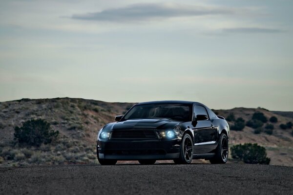 Ford Mustang negro en un fondo sombrío