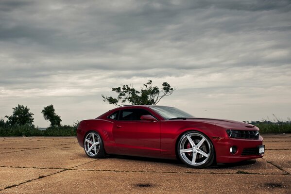 Una Chevrolet Camaro rossa su un lotto vuoto