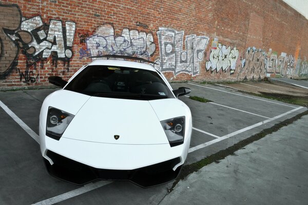 Vue de face de Lamborghini blanc avec phares trapézoïdaux sur le parking