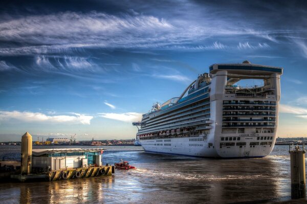 Under the blue sky, the liner docks at the pier