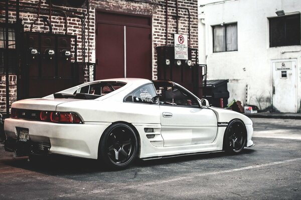 Toyota MR2 blanc sur fond de maison en brique