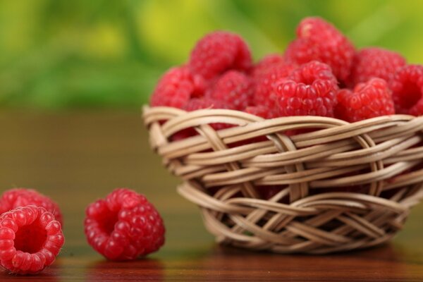 Raspberries in a wicker vase on the table