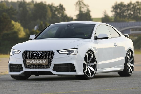 White Audi A5 on a background of trees