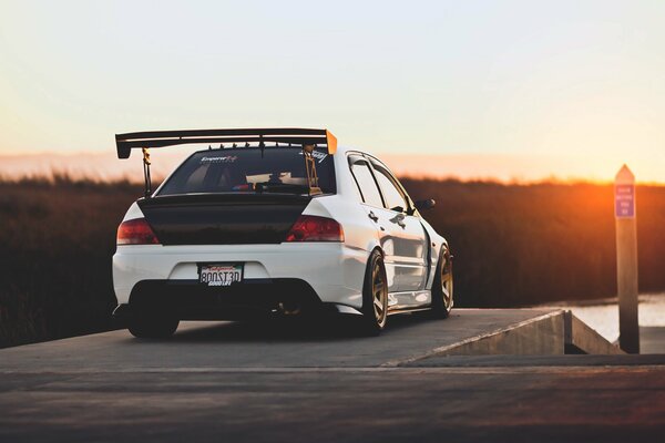 Mitsubishi lancer evo white is standing by the window