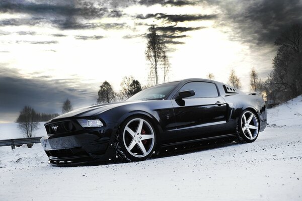 Ford Mustang noir sur fond de paysage d hiver