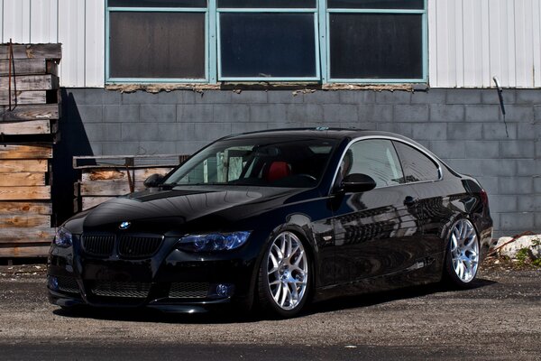 Black BMW and grey wall with windows