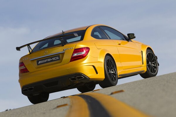 Yellow Mercedes-benz amg breaks the double solid on the track